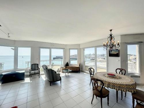 un salon avec une table et des chaises et l'océan dans l'établissement Magnifique appartement en front de mer avec parking et Wi-Fi à Granville - FR-1-361-516, à Granville