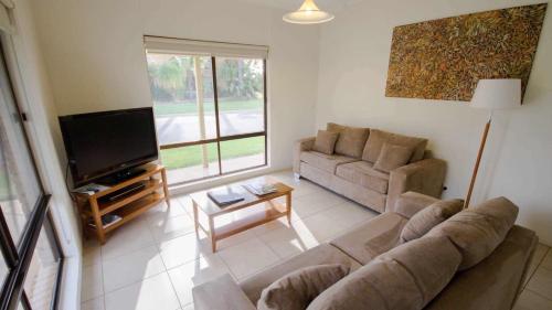 a living room with a couch and a flat screen tv at Sunraysia Resort Mildura in Mildura