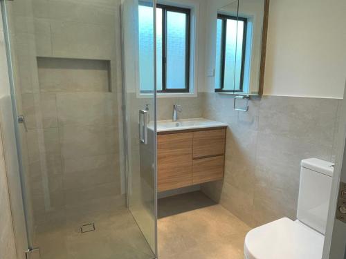 a bathroom with a shower and a sink and a toilet at Alwyns By The Sea in Inverloch