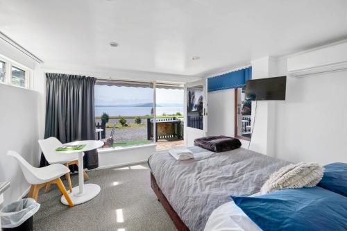 a bedroom with a bed and a desk and a window at Lakeview Small Studio in Rotorua
