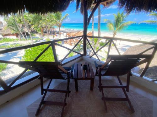 a room with two chairs and a table and the beach at BT Live Tulum located at the party zone in Tulum