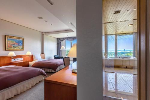 ein Hotelzimmer mit 2 Betten und einem Bad in der Unterkunft KAMENOI HOTEL Aomori Makado in Noheji