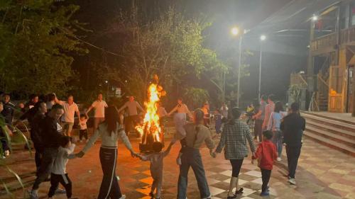 a group of people standing around a large fire at Cao nguyên in Mộc Châu
