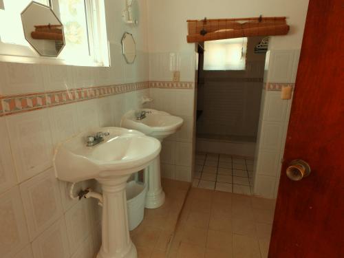 a white bathroom with a sink and a shower at CANCUN PRIVATE APARTMENT in Cancún