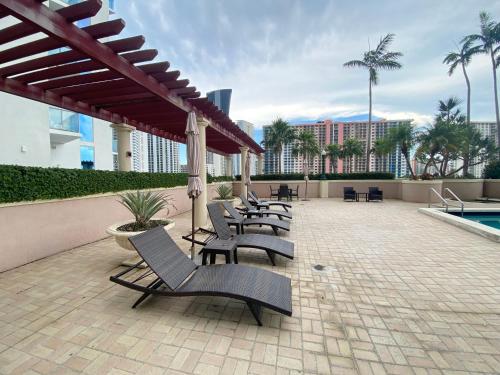 een patio met een aantal stoelen en een zwembad bij The King David Condos in Miami Beach