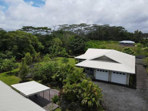 an aerial view of a house with a white roof at Hale ‘Aina (Country Cottage) in Keaau