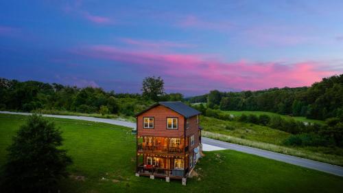 a house sitting on top of a green field at Huny Bear Lodge in Pigeon Forge