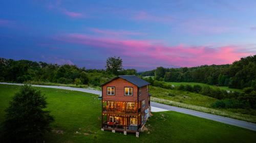 uma casa em cima de um campo verde em Huny Bear Lodge em Pigeon Forge