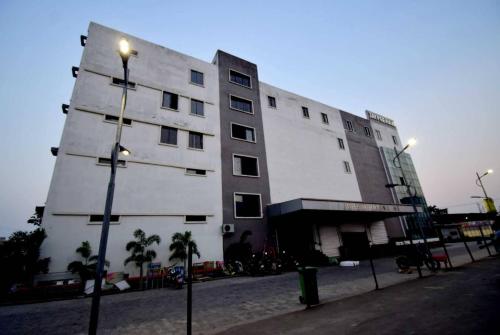 a tall white building with a street light in front of it at OYO Flagship Bengal Inn in Sānkrāil