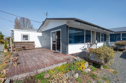 a house with a wooden deck in front of it at Jack & Di's Lakefront Motel in Rotorua