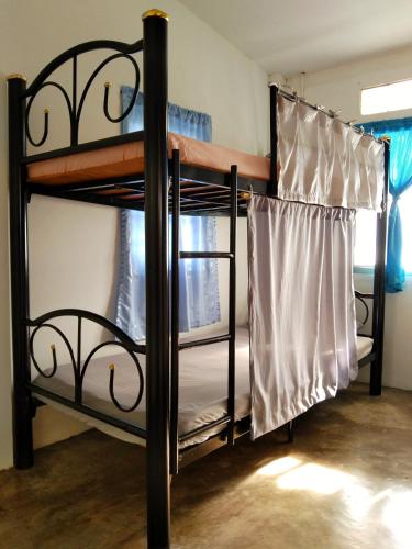 two bunk beds in a room with a window at The Dreamcatcher Hostel Nathon SamuiSunset in Nathon