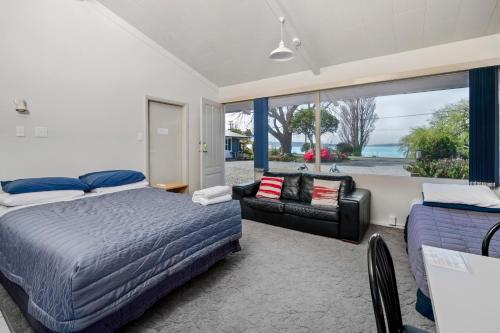 a bedroom with two beds and a couch at Jack & Di's Lakefront Motel in Rotorua