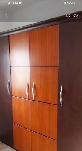 a wooden closet with wooden doors and handles at Hotel appointment service in ‘Izbat Jamaşah al Gharbīyah