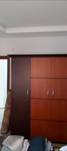 a bedroom with a wooden dresser and brown cabinets at Hotel appointment service in ‘Izbat Jamaşah al Gharbīyah