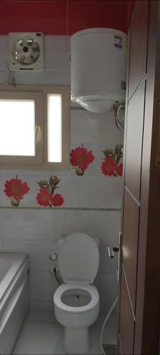 a small bathroom with a toilet and a window at Hotel appointment service in ‘Izbat Jamaşah al Gharbīyah