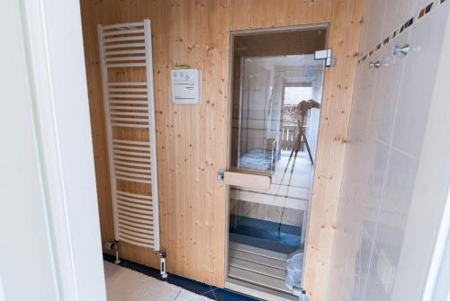 uma casa de banho com um chuveiro e uma parede de madeira em Modern Living Traditional Style em Altenmarkt im Pongau