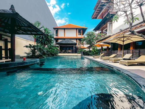 a swimming pool in the middle of a building at Bali Summer Hotel by Amerta in Kuta