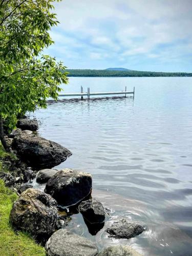 a large body of water with rocks and a dock at Chalet Le Shack in Stratford