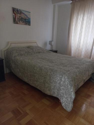Un dormitorio con una cama con una manta. en Hermoso y luminoso en Palermo / Recoleta en Buenos Aires