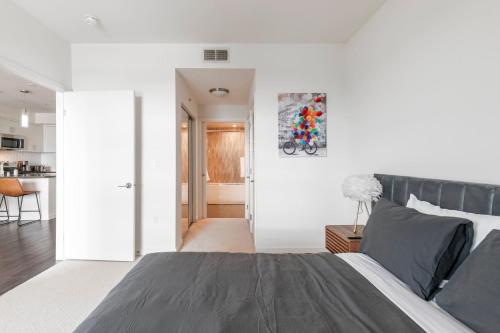 a bedroom with a large bed and a kitchen at Brand New Luxury Apartment WeHo in Los Angeles