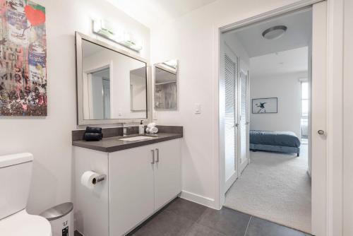een witte badkamer met een wastafel en een spiegel bij Brand New Luxury Apartment WeHo in Los Angeles