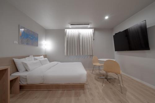 a bedroom with a bed and a desk and a television at Cheonan Aank Hotel Seongjeong in Cheonan