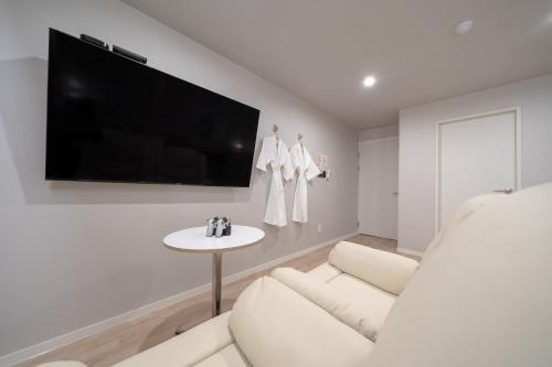 a white living room with a white couch and a tv at Cheonan Aank Hotel Seongjeong in Cheonan