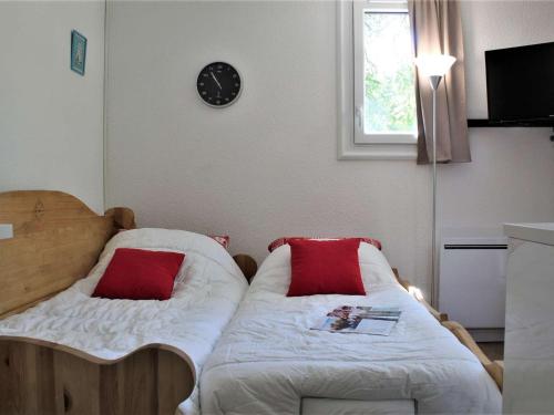 - une chambre avec 2 lits et une horloge murale dans l'établissement Studio 4 pers. avec balcon sud, calme, parking gratuit - Risoul 1850 - FR-1-330-567, à Risoul