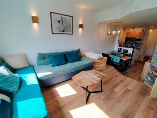 un salon avec un canapé bleu et une table dans l'établissement Avoriaz: Appartement cosy 3 pièces pour 5 pers avec WiFi, TV, appareil à raclette - FR-1-633-77, à Morzine