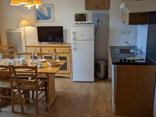 une cuisine avec une table et un réfrigérateur blanc dans l'établissement Appartement lumineux 6 pers, pied des pistes, commerces, bien équipé - FR-1-262-184, à Orcières