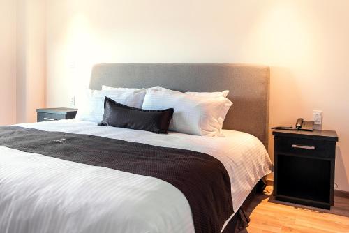 um quarto com uma cama grande e uma mesa de cabeceira em Sendero Hotel em Actopan