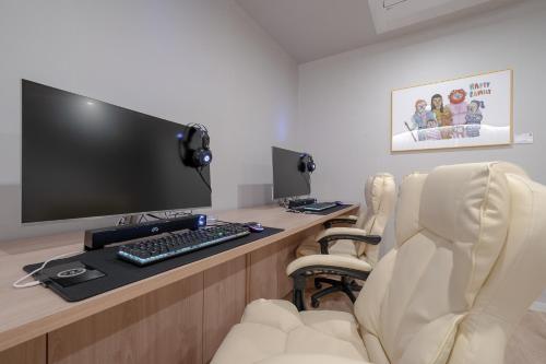 a room with a desk with a computer and two chairs at Cheonan Aank Hotel Seongjeong in Cheonan