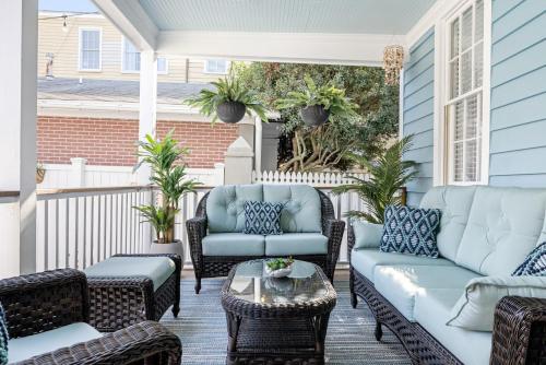 a porch with couches and chairs and a table at Hidden Outdoor Oasis - 1 BLOCK TO KING in Charleston