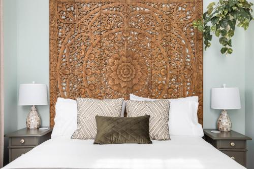1 cama con cabecero de madera grande y 2 mesitas de noche en Charming Secluded Courtyard - 1 BLOCK TO KING, en Charleston
