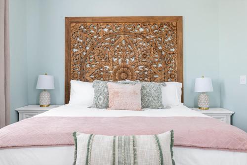a bedroom with a large bed with a wooden headboard at Stunning Secret Courtyard - 1 BLOCK TO KING in Charleston