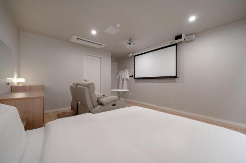 a bedroom with a white bed and a tv at Cheonan Aank Hotel Seongjeong in Cheonan