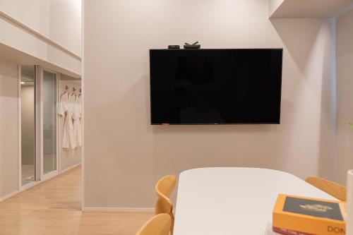 a living room with a flat screen tv on a wall at Cheonan Aank Hotel Seongjeong in Cheonan