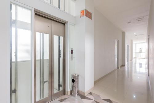 a hallway with a glass door in a building at RedDoorz Plus near Living Plaza Jababeka in Bekasi
