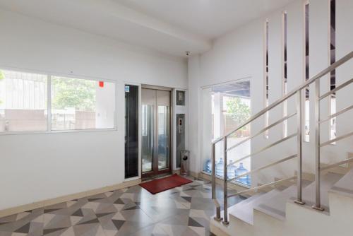 a living room with stairs and a red rug at RedDoorz Plus near Living Plaza Jababeka in Bekasi