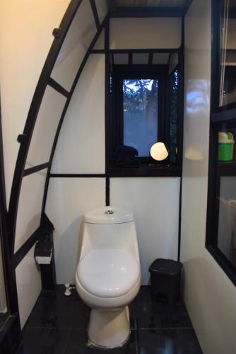 a white toilet in a room with a window at Chalet Tanat in Santa Elena