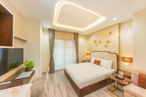 um quarto de hotel com uma cama, uma secretária e um computador em Simmi Apartment Phu My Hung em Ho Chi Minh