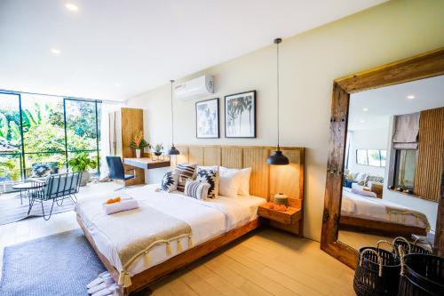 ein Schlafzimmer mit einem großen Bett und einem großen Fenster in der Unterkunft Tropical Comfort - Private Pool Modern Townhouse in Canggu