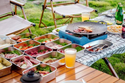 een picknicktafel met borden met eten en drinken bij Brandy Manor Wild Luxury B&B - Jinzhai Branch in Jinzhai