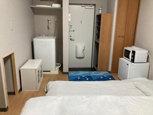 a room with a bed and a microwave in it at Sky Tree INN (晴樹宿）stay ASAKUSA in Tokyo