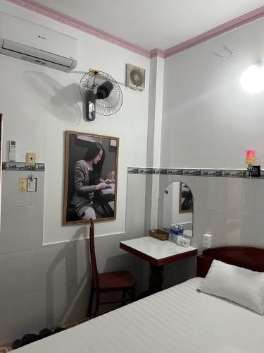 a room with a bed and a table and a mirror at Mai Phương Thúy Motel in Bien Hoa