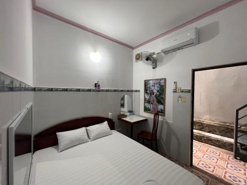 een slaapkamer met een bed en een bureau. bij Mai Phương Thúy Motel in Bien Hoa