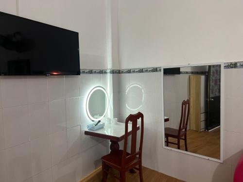 a room with two mirrors and a table with a chair at Mai Phương Thúy Motel in Bien Hoa