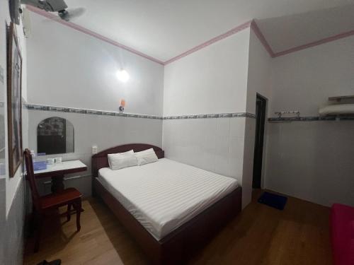 a small bedroom with a bed and a small table at Mai Phương Thúy Motel in Bien Hoa