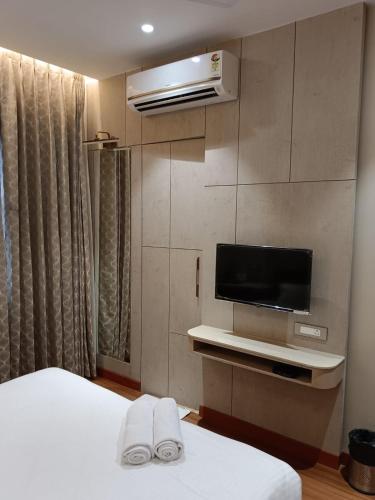 a hotel room with a bed and a flat screen tv at Buddha Stays in Varanasi