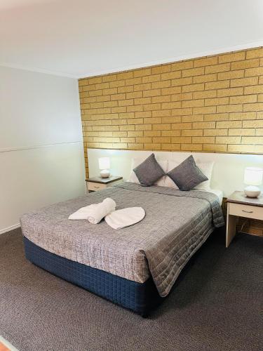 a bedroom with a bed with two pillows on it at Mundubbera Motel in Mundubbera